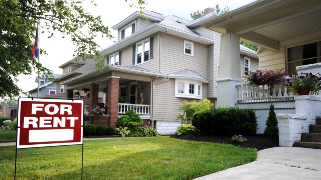 A house with a 'For Rent' sign in the front yard.