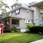 A house with a 'For Rent' sign in the front yard.