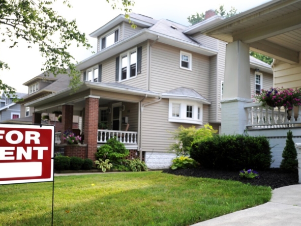 A house with a 'For Rent' sign in the front yard.